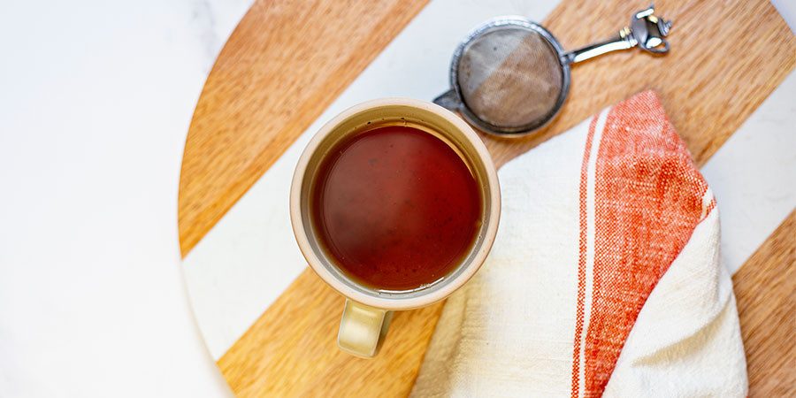 herbal tea in mug and tea strainer