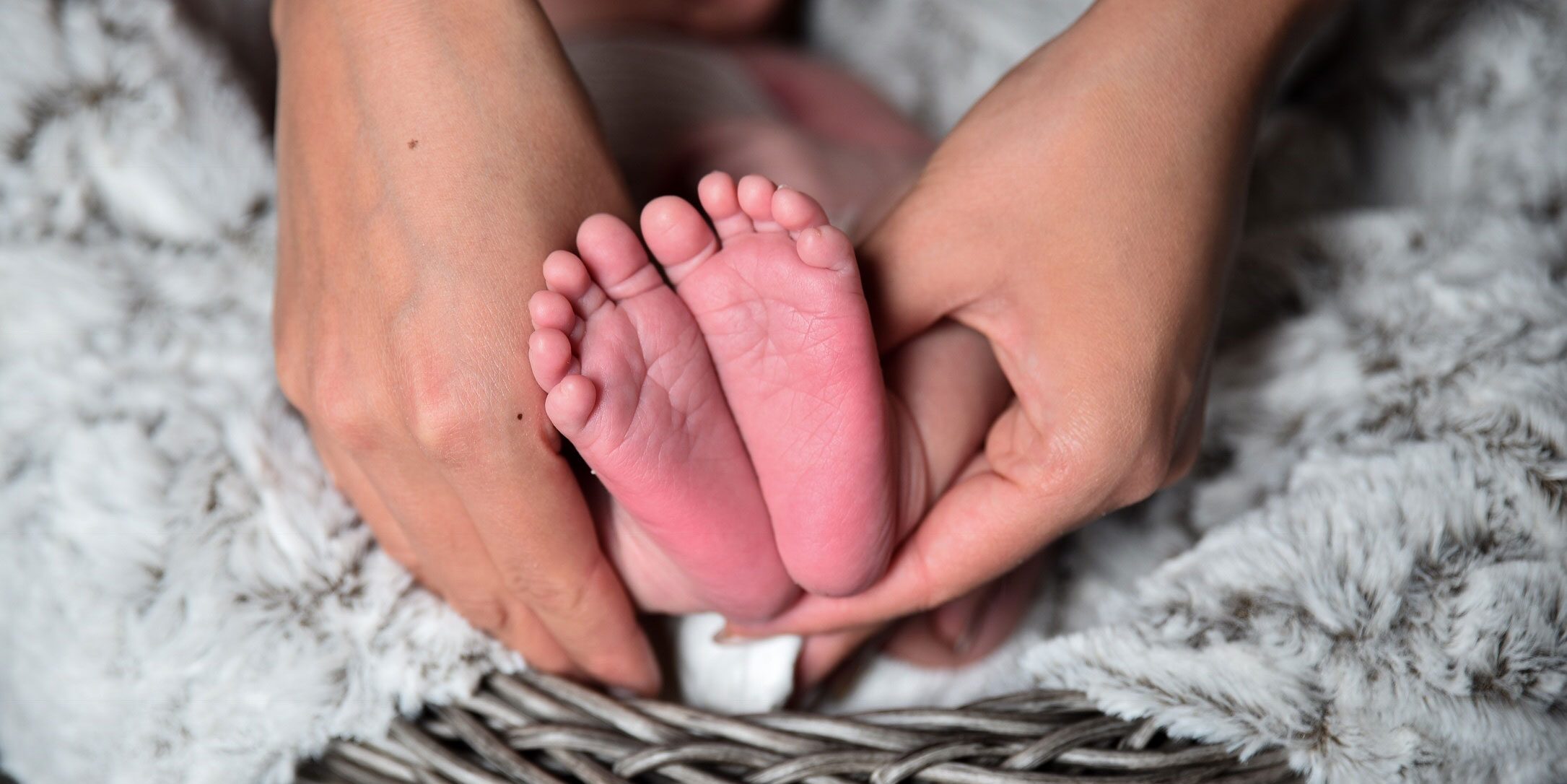 mother's hands holding baby feet