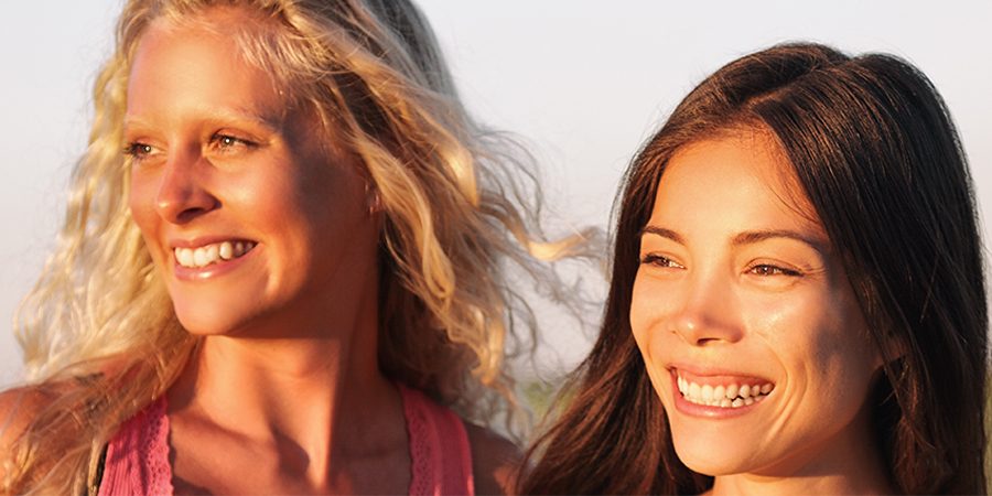 two women with sun shining on glowing skin